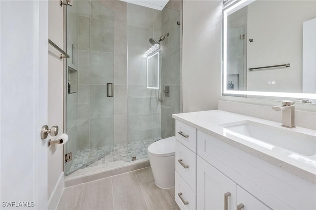 bathroom with vanity, toilet, and a shower with shower door