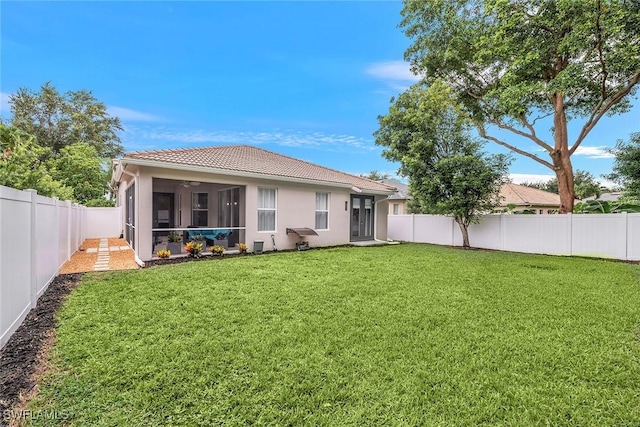 rear view of property with a sunroom and a yard