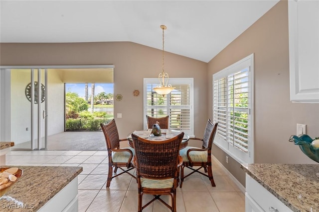 dining space featuring lofted ceiling and light tile patterned floors