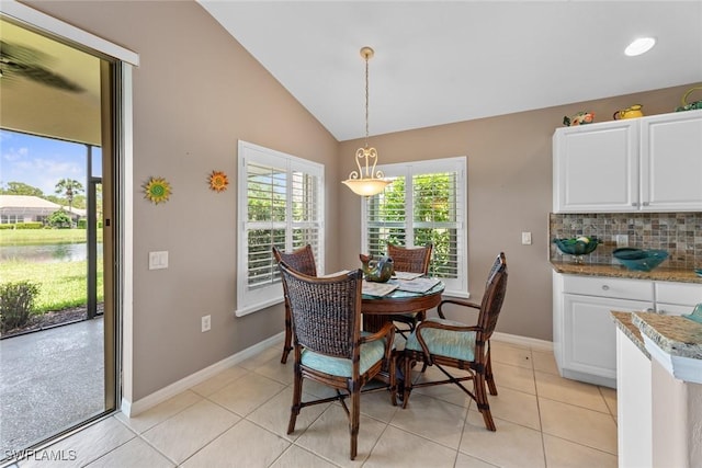 tiled dining room with lofted ceiling