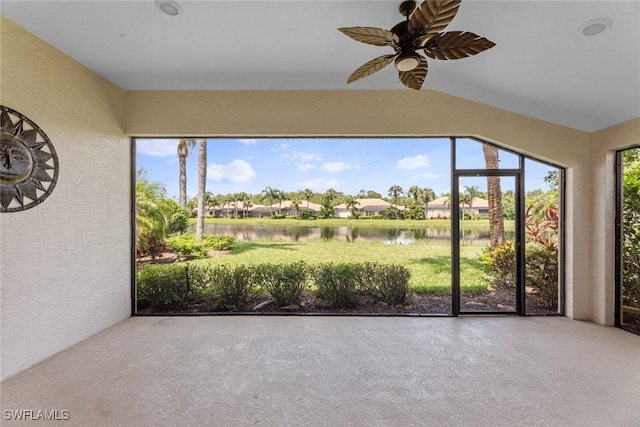 unfurnished sunroom featuring ceiling fan, a water view, and a healthy amount of sunlight