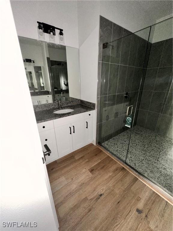 bathroom featuring vanity, an enclosed shower, and hardwood / wood-style flooring