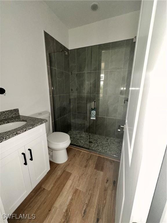 bathroom featuring vanity, toilet, an enclosed shower, and wood-type flooring