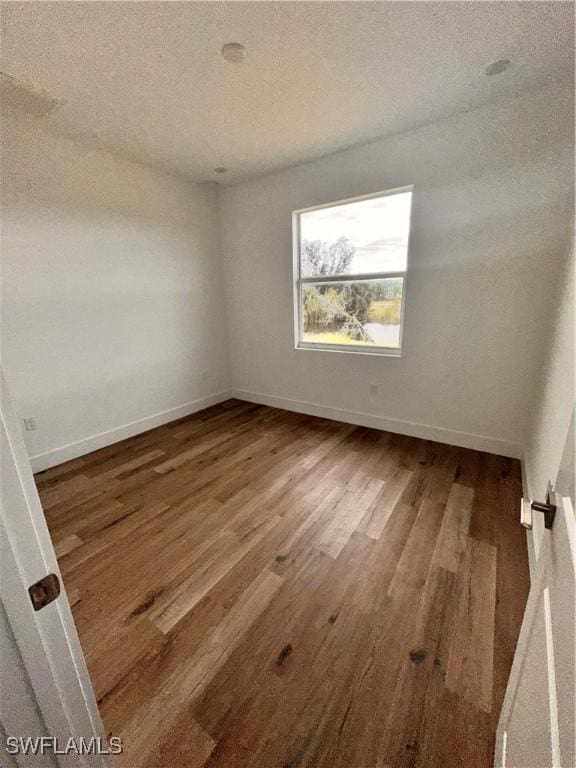 empty room featuring hardwood / wood-style flooring and a textured ceiling