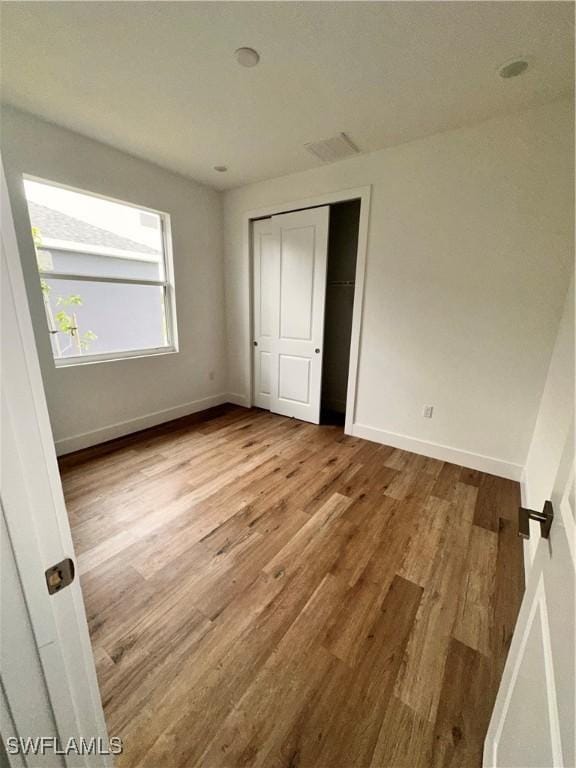 unfurnished bedroom featuring light hardwood / wood-style floors and a closet