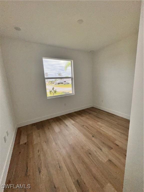 unfurnished room with hardwood / wood-style floors