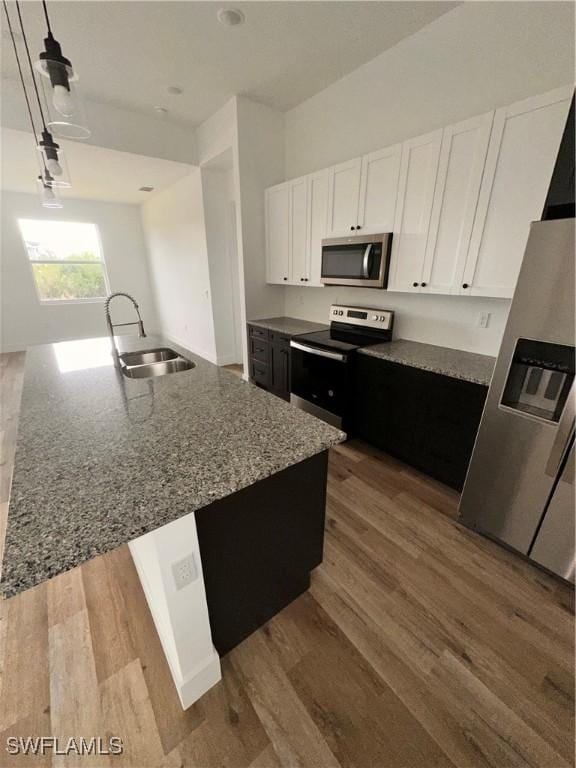 kitchen with sink, white cabinets, stainless steel appliances, and stone countertops