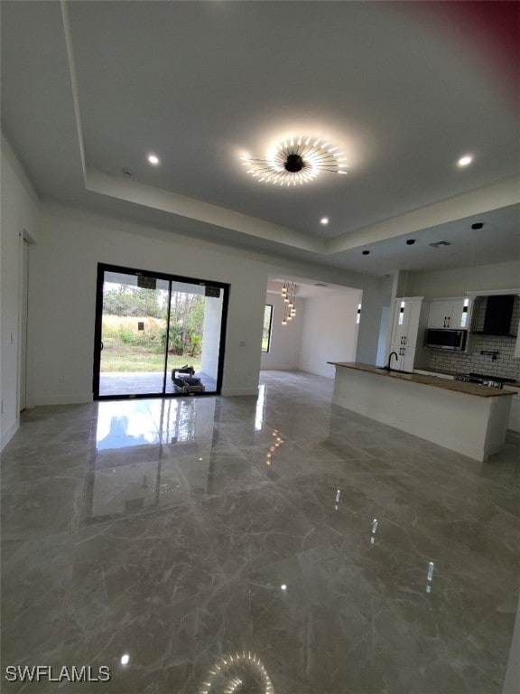 unfurnished living room featuring a raised ceiling