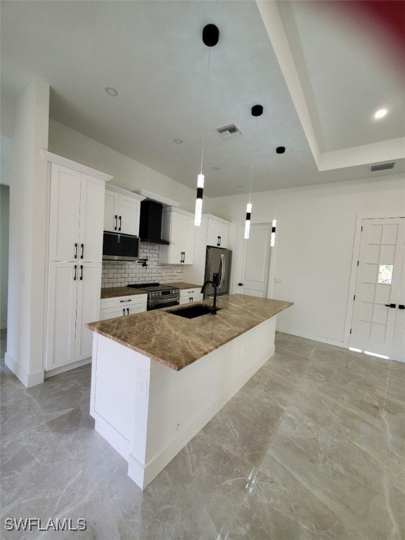 kitchen featuring pendant lighting, a kitchen island with sink, white cabinets, sink, and appliances with stainless steel finishes