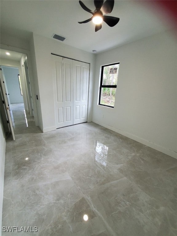 unfurnished bedroom featuring ceiling fan and a closet