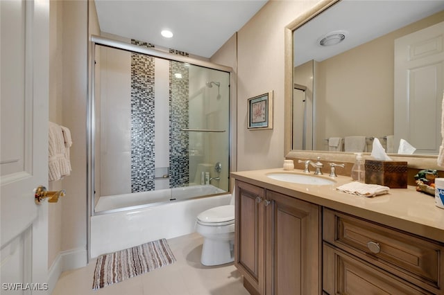 bathroom featuring vanity, shower / bath combination with glass door, tile patterned flooring, and toilet