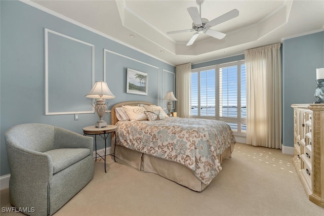 bedroom featuring a raised ceiling, light colored carpet, crown molding, and ceiling fan