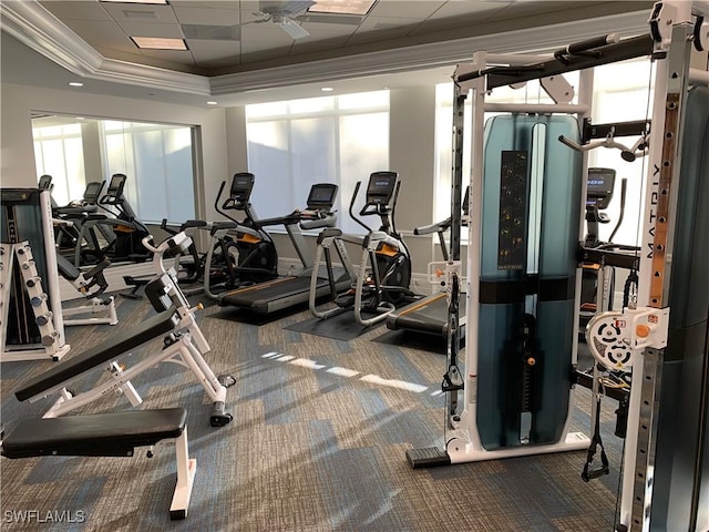 gym with carpet floors, a raised ceiling, crown molding, and ceiling fan