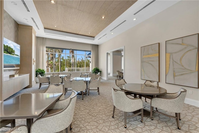 dining space with light carpet and a raised ceiling