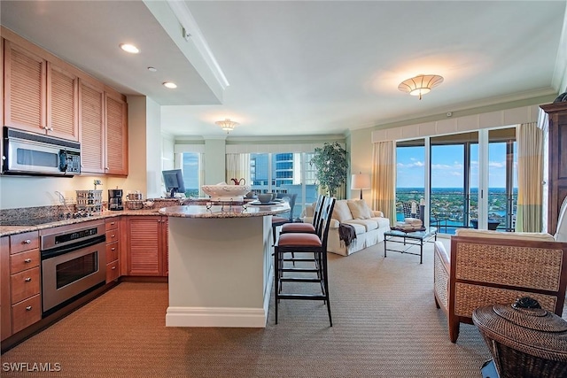 kitchen featuring appliances with stainless steel finishes, plenty of natural light, a breakfast bar, and kitchen peninsula