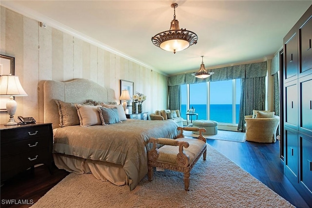 bedroom featuring a water view, ornamental molding, and dark hardwood / wood-style flooring