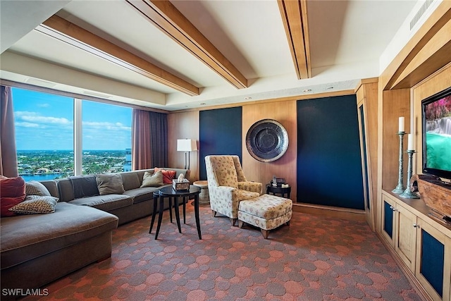 carpeted living room with beamed ceiling