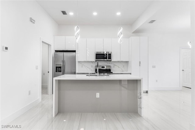 kitchen featuring a kitchen island with sink, sink, hanging light fixtures, white cabinetry, and stainless steel appliances