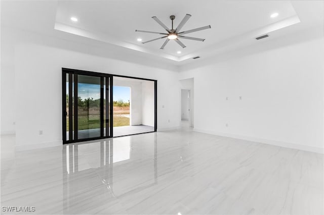 empty room with a tray ceiling and ceiling fan