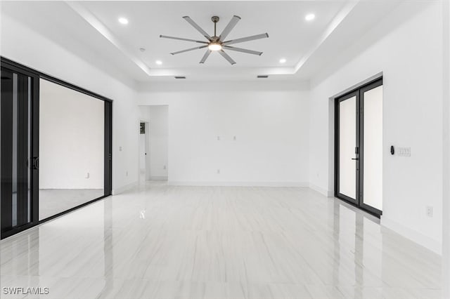 unfurnished room featuring ceiling fan, french doors, and a tray ceiling