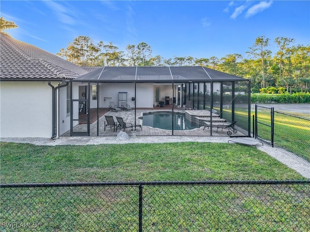 rear view of property featuring a fenced in pool, a patio area, glass enclosure, and a lawn