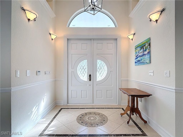 tiled foyer featuring an inviting chandelier