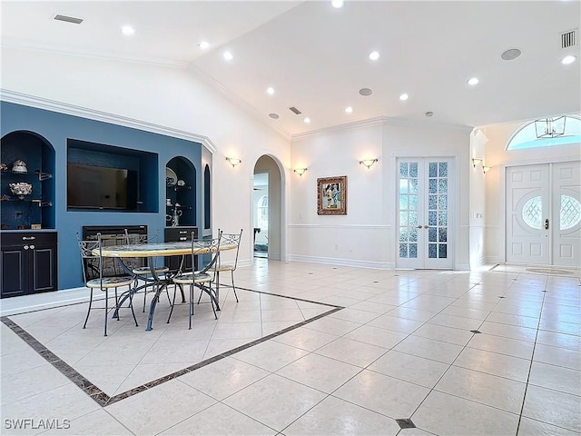 dining space with vaulted ceiling, light tile patterned flooring, built in features, crown molding, and french doors