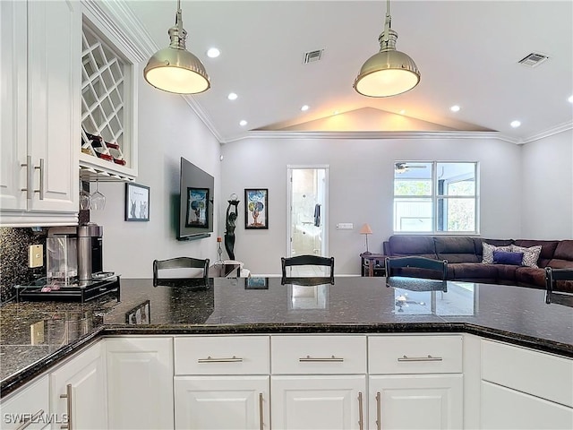 kitchen featuring pendant lighting, white cabinetry, and crown molding