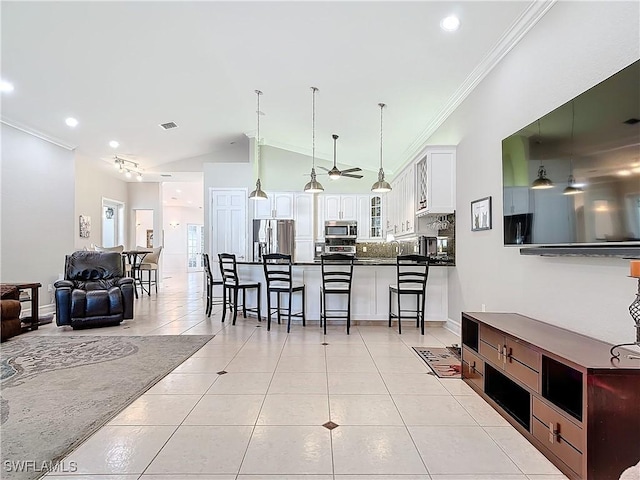 interior space with white cabinetry, a kitchen bar, light tile patterned flooring, and appliances with stainless steel finishes