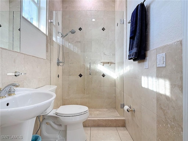 bathroom featuring toilet, an enclosed shower, tile patterned flooring, and tile walls