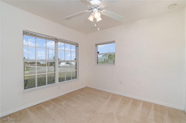 spare room featuring light colored carpet and ceiling fan