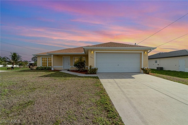 ranch-style house featuring cooling unit, a garage, and a yard