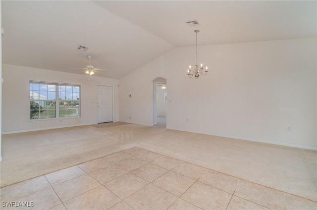 empty room with ceiling fan with notable chandelier, light tile patterned floors, and vaulted ceiling