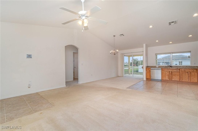 unfurnished living room featuring light carpet, sink, ceiling fan with notable chandelier, and lofted ceiling