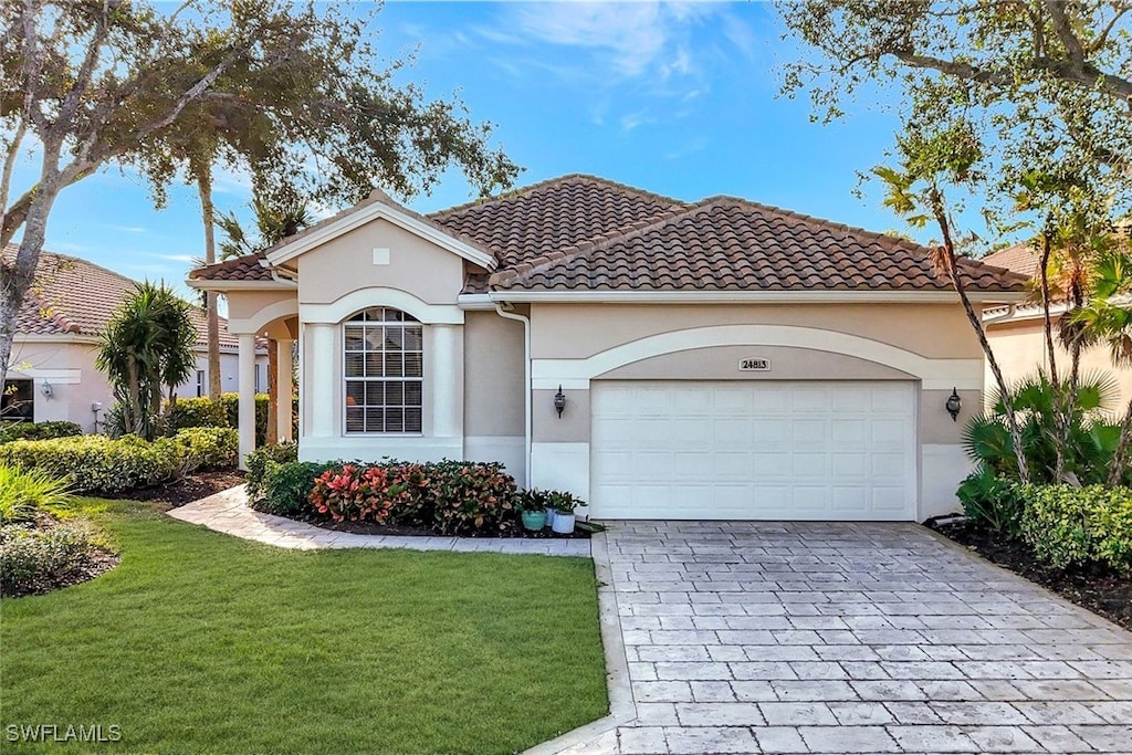 mediterranean / spanish home with a front yard and a garage