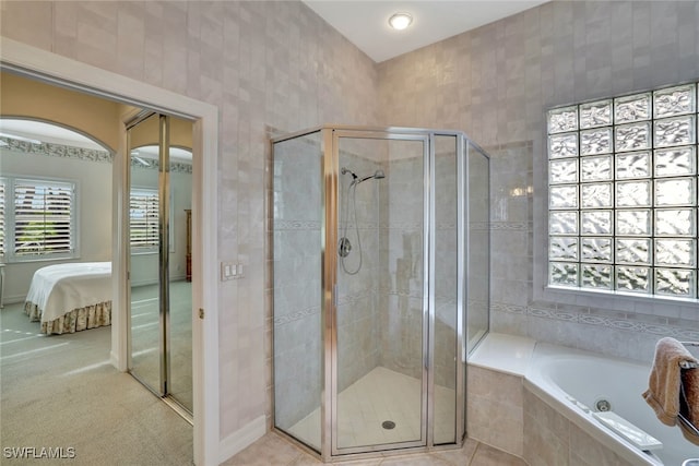 bathroom with tile patterned flooring and shower with separate bathtub