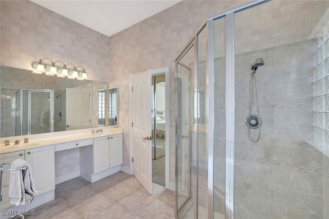 bathroom featuring tile patterned floors, an enclosed shower, and vanity