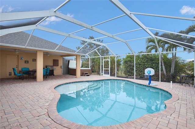 view of pool featuring ceiling fan, a hot tub, a patio area, and glass enclosure