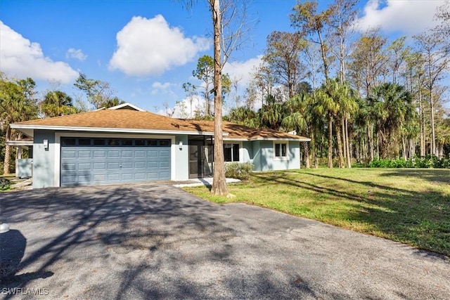 ranch-style home with a garage, stucco siding, driveway, and a front yard