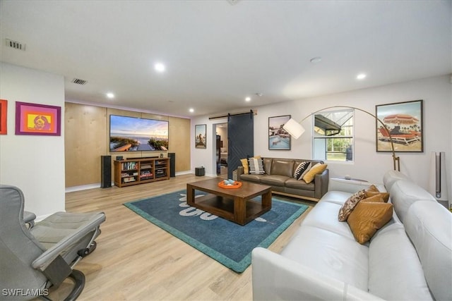 living room featuring visible vents, recessed lighting, light wood finished floors, and a barn door