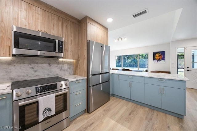 kitchen with tasteful backsplash, light wood-style flooring, appliances with stainless steel finishes, visible vents, and a peninsula