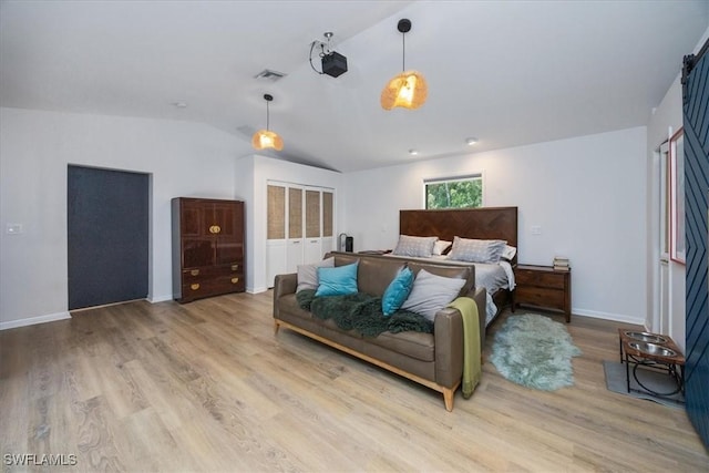 bedroom featuring lofted ceiling, wood finished floors, visible vents, and baseboards