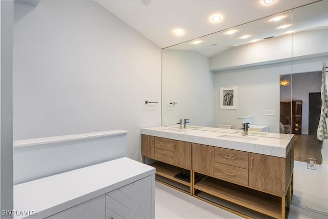 bathroom featuring vanity and lofted ceiling