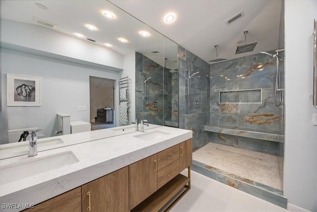 bathroom with visible vents, a stall shower, double vanity, and a sink