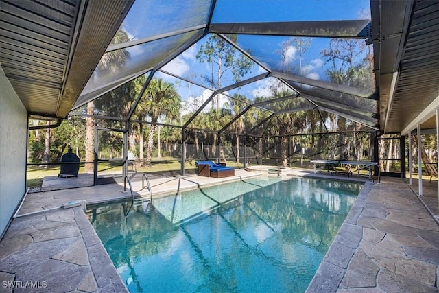 pool with glass enclosure, an in ground hot tub, and a patio area
