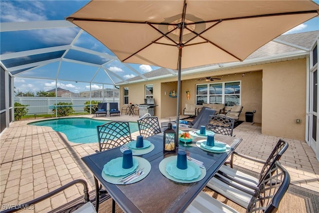 view of swimming pool with ceiling fan, a lanai, and a patio