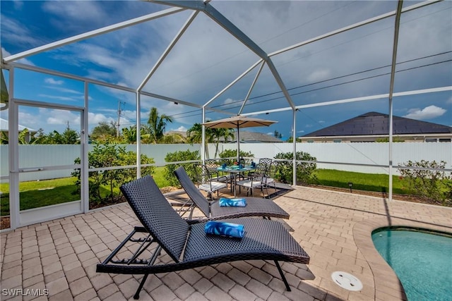 view of pool with glass enclosure and a patio area