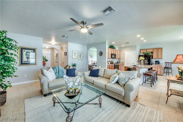 living room with ceiling fan, light tile patterned flooring, and sink