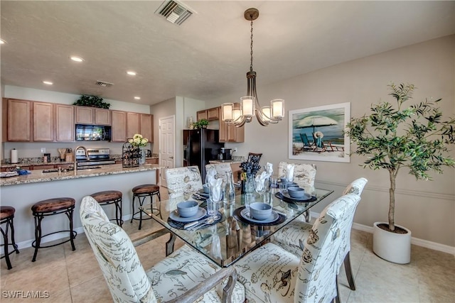 tiled dining area featuring a notable chandelier and sink