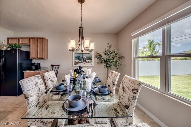 tiled dining room with a chandelier and a healthy amount of sunlight